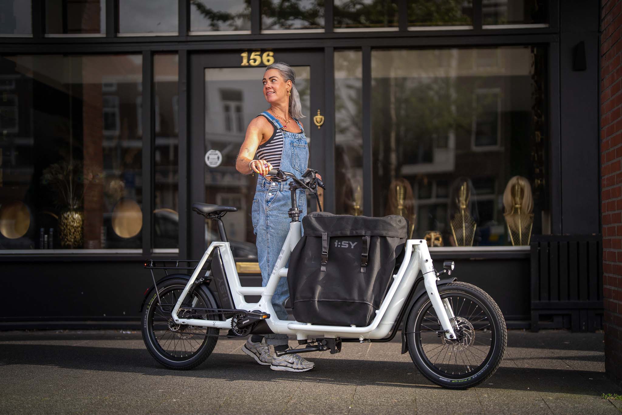 i:SY E-Bike mit Person vor Laden – Szene aus einem Werbefilm für die Firma i:SY GmbH & Co. KG, produziert von Charlie Grashoff - The C/A Studio, Videoproduktion in Leipzig. Projekte deutschlandweit. Imagefilme, Corporate Videos, Brandfilme, Eventfilme, Industriefilme & mehr. Werbefilm Produktion. Fotografie Leipzig.