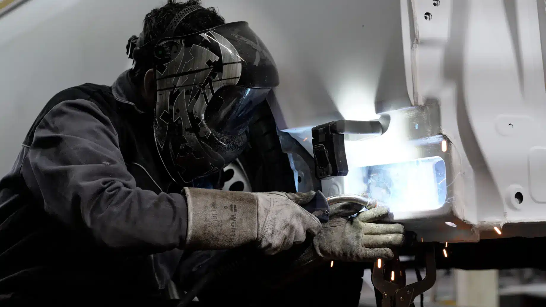 Mitarbeiter der LackPlus GmbH schweißt Autoteile in Werkstatt – Szene aus einem Imagefilm für die Firma Lackplus GmbH, produziert von Charlie Grashoff - The C/A Studio, Videoproduktion in Leipzig. Projekte deutschlandweit. Imagefilme, Corporate Videos, Brandfilme, Eventfilme, Industriefilme & mehr.